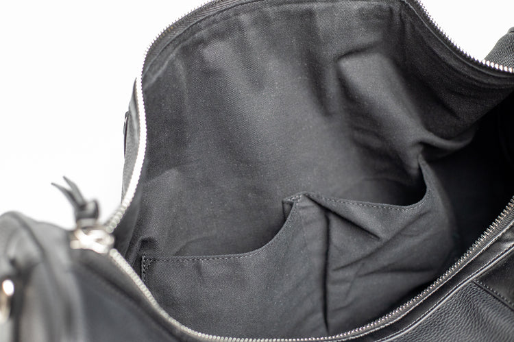 El Doler Black Duffel bag close up photo two sewn lining side pockets